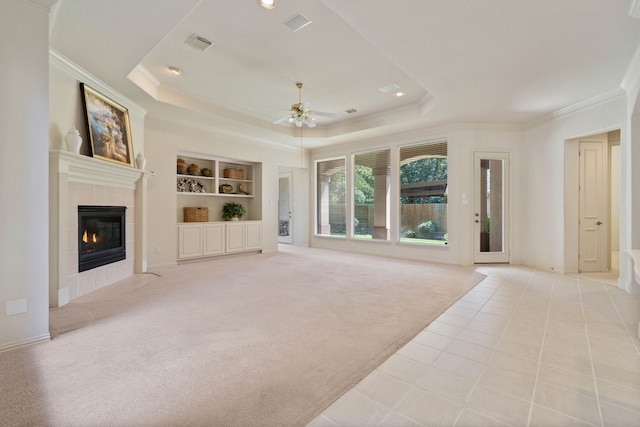102 W Racing Cloud Ct, The Woodlands, TX 77381 - unfurnished living room featuring a ceiling fan, crown molding, built in features, a raised ceiling, and a fireplace