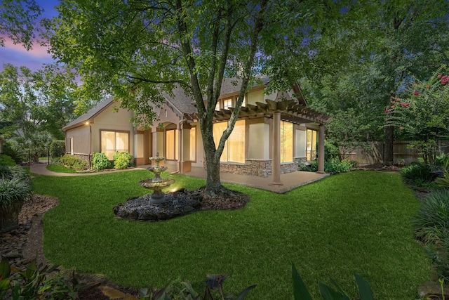 102 W Racing Cloud Ct, The Woodlands, TX 77381 - back of house at dusk with stucco siding and a pergola