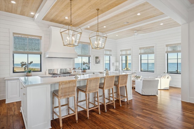 4223 Swashbuckle, Galveston, TX 77554 - kitchen with dark wood-style floors, custom exhaust hood, light countertops, a spacious island, and white cabinets