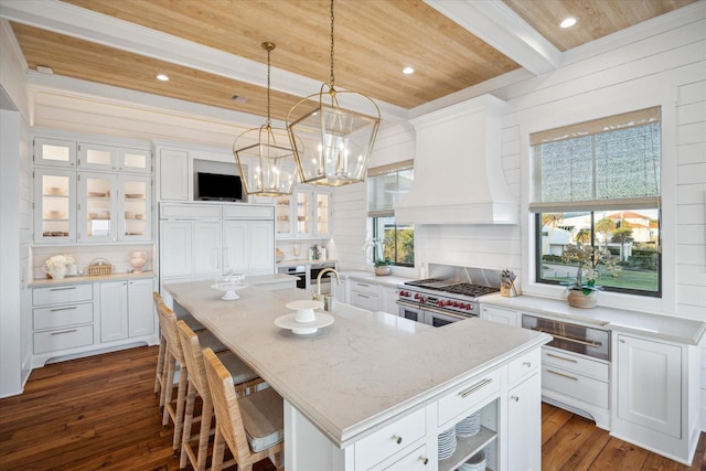 4223 Swashbuckle, Galveston, TX 77554 - kitchen with a wooden ceiling with exposed beams, a warming drawer, white cabinetry, dark wood-style flooring, and an island with sink