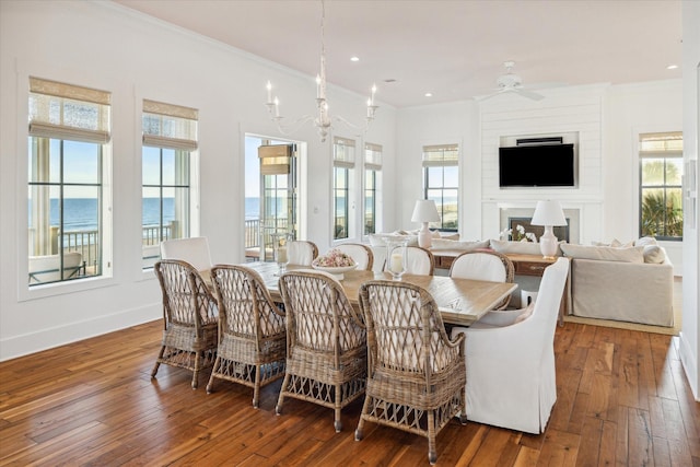 4223 Swashbuckle, Galveston, TX 77554 - dining space featuring ornamental molding, hardwood / wood-style floors, ceiling fan, a fireplace, and a chandelier
