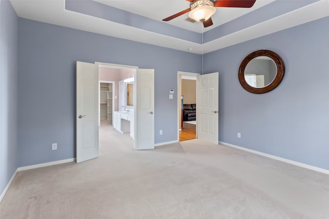 402 Starleaf Ln, Pearland, TX 77584 - unfurnished bedroom featuring carpet flooring, a raised ceiling, a walk in closet, and a ceiling fan