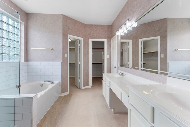 402 Starleaf Ln, Pearland, TX 77584 - bathroom featuring a walk in closet, double vanity, and plenty of natural light