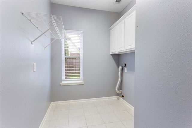 402 Starleaf Ln, Pearland, TX 77584 - laundry room featuring cabinet space, light tile patterned flooring, and hookup for an electric dryer