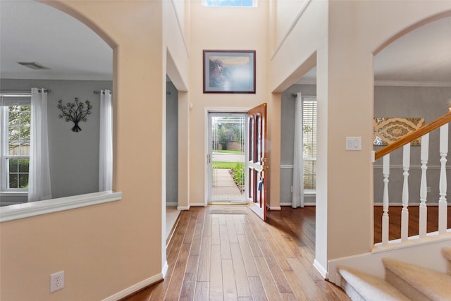 402 Starleaf Ln, Pearland, TX 77584 - entryway featuring healthy amount of natural light, wood-type flooring, stairs, arched walkways, and ornamental molding