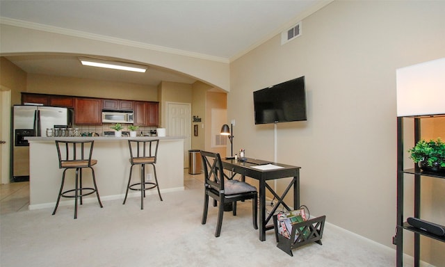 6607 Lake Woodlands Dr Unit 223, The Woodlands, TX 77382 - kitchen with appliances with stainless steel finishes, arched walkways, ornamental molding, a kitchen bar, and light carpet