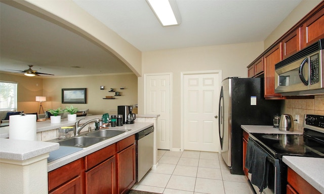 6607 Lake Woodlands Dr Unit 223, The Woodlands, TX 77382 - kitchen featuring appliances with stainless steel finishes, light tile patterned floors, arched walkways, open floor plan, and light countertops