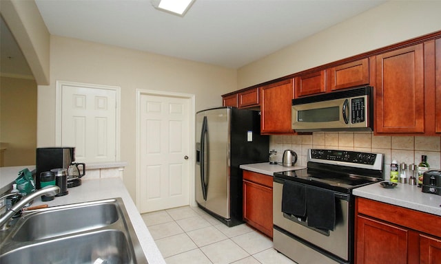 6607 Lake Woodlands Dr Unit 223, The Woodlands, TX 77382 - kitchen with appliances with stainless steel finishes, light tile patterned floors, light countertops, and decorative backsplash