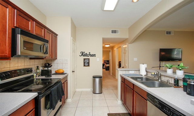 6607 Lake Woodlands Dr Unit 223, The Woodlands, TX 77382 - kitchen featuring stainless steel appliances, decorative backsplash, light countertops, and arched walkways