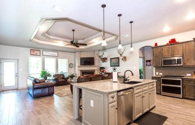 2977 Presidio Cir, Belton, TX 76513 - kitchen with stainless steel appliances, ceiling fan, light wood-type flooring, arched walkways, and ornamental molding