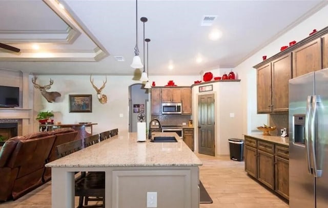 2977 Presidio Cir, Belton, TX 76513 - kitchen featuring stainless steel appliances, open floor plan, backsplash, a breakfast bar area, and light stone counters