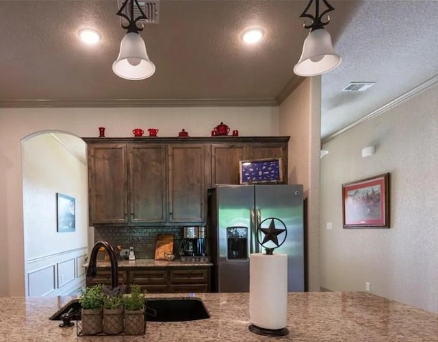 2977 Presidio Cir, Belton, TX 76513 - kitchen featuring stainless steel fridge with ice dispenser, ornamental molding, hanging light fixtures, light stone counters, and a textured ceiling