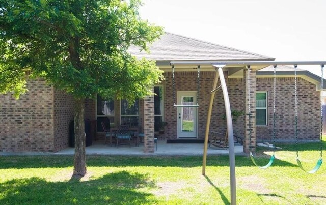 2977 Presidio Cir, Belton, TX 76513 - back of house featuring brick siding, a yard, roof with shingles, and a patio