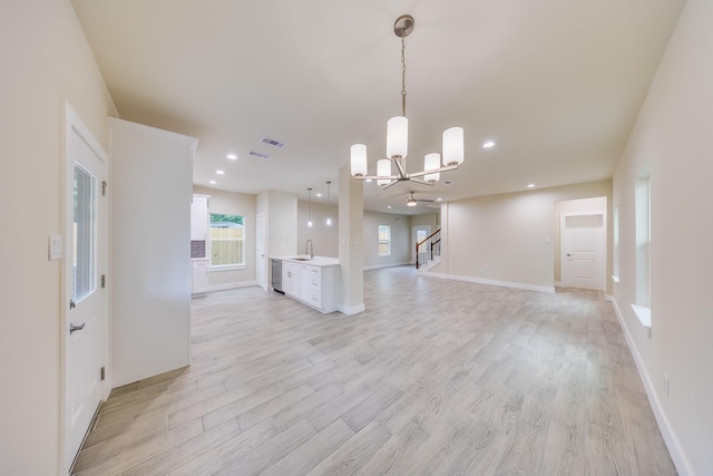 10512 Exeter St, Houston, TX 77093 - unfurnished living room featuring a chandelier, stairway, light wood-type flooring, and recessed lighting