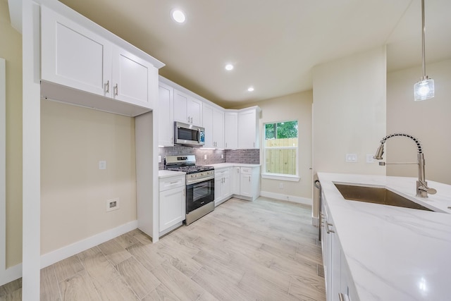 10512 Exeter St, Houston, TX 77093 - kitchen featuring appliances with stainless steel finishes, tasteful backsplash, light stone counters, white cabinetry, and recessed lighting