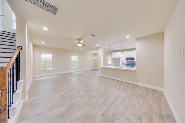 10512 Exeter St, Houston, TX 77093 - unfurnished living room with ceiling fan, light wood-type flooring, stairs, and recessed lighting