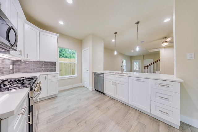 10512 Exeter St, Houston, TX 77093 - kitchen with stainless steel appliances, a peninsula, recessed lighting, backsplash, and light countertops