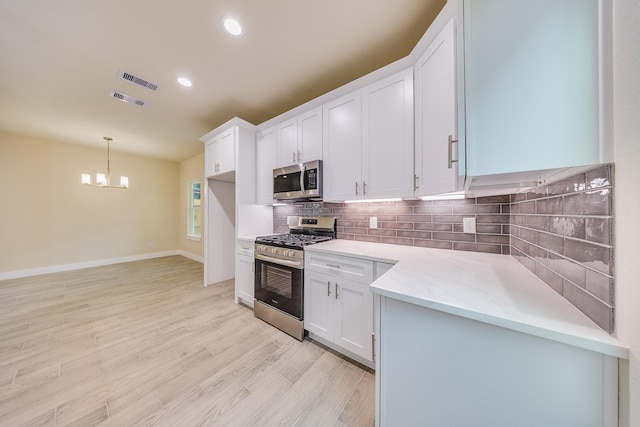 10512 Exeter St, Houston, TX 77093 - kitchen featuring appliances with stainless steel finishes, backsplash, white cabinetry, light wood-type flooring, and recessed lighting