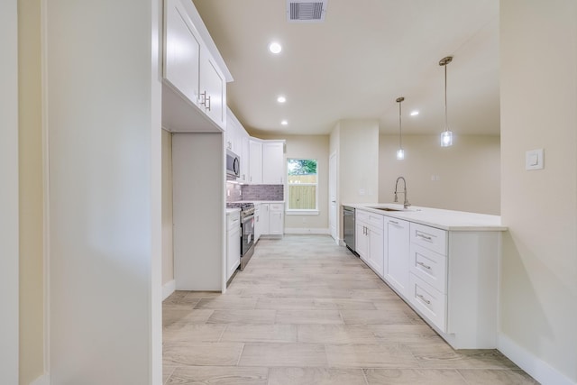 10512 Exeter St, Houston, TX 77093 - kitchen with a peninsula, appliances with stainless steel finishes, decorative backsplash, recessed lighting, and light countertops