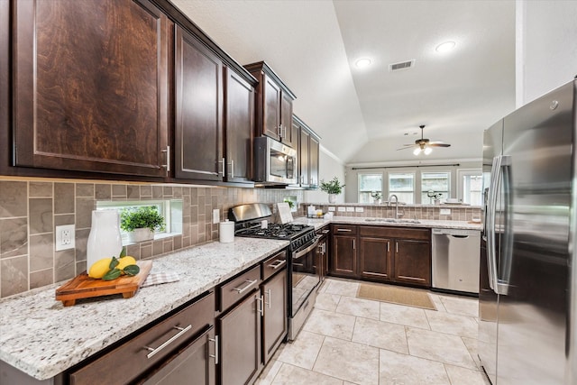 31703 Morning Ridge Ln, Spring, TX 77386 - kitchen with appliances with stainless steel finishes, tasteful backsplash, dark brown cabinetry, vaulted ceiling, and a ceiling fan