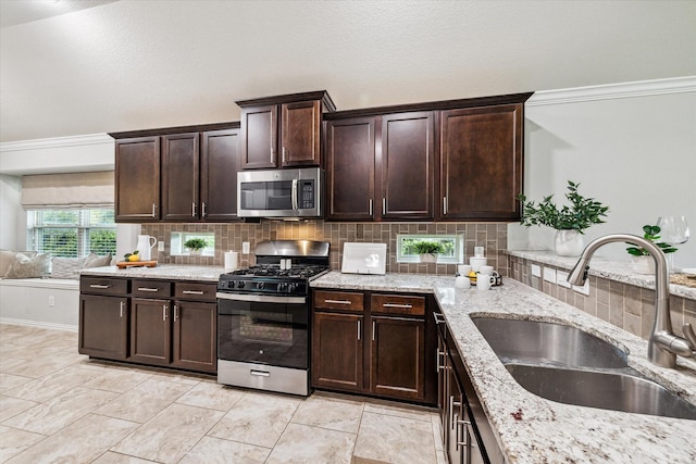 31703 Morning Ridge Ln, Spring, TX 77386 - kitchen featuring stainless steel appliances, backsplash, dark brown cabinetry, light stone countertops, and crown molding
