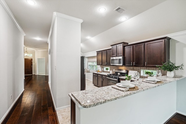 31703 Morning Ridge Ln, Spring, TX 77386 - kitchen featuring stainless steel appliances, dark brown cabinetry, light stone counters, tasteful backsplash, and a peninsula