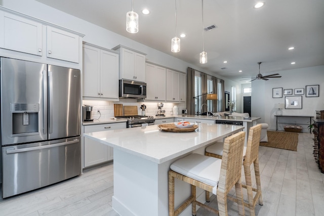 17746 Tree Of Heaven, Conroe, TX 77385 - kitchen featuring stainless steel appliances, a peninsula, light countertops, tasteful backsplash, and a kitchen island