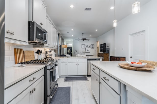 17746 Tree Of Heaven, Conroe, TX 77385 - kitchen with appliances with stainless steel finishes, a peninsula, light countertops, ceiling fan, and recessed lighting