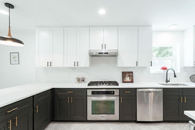 28926 Twisted Oak Dr, Shenandoah, TX 77381 - kitchen with stainless steel appliances, under cabinet range hood, white cabinets, tasteful backsplash, and recessed lighting