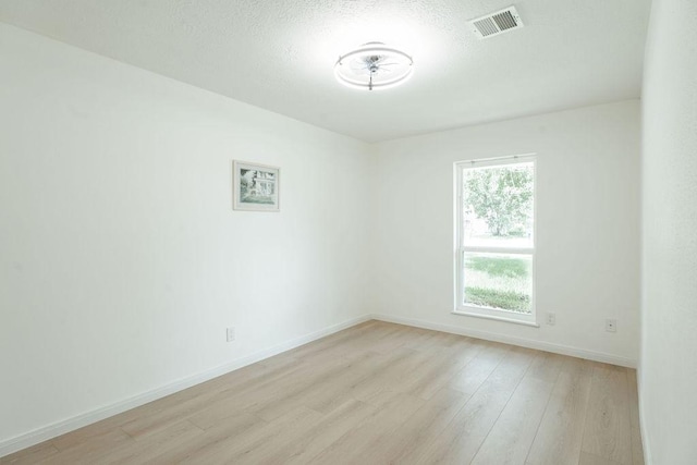 28926 Twisted Oak Dr, Shenandoah, TX 77381 - empty room with light wood finished floors and a textured ceiling