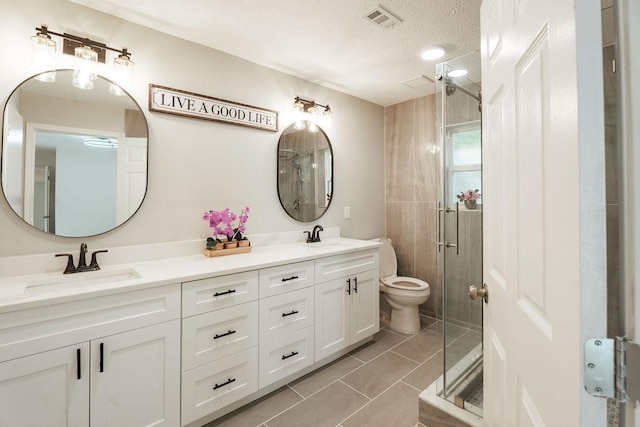 28926 Twisted Oak Dr, Shenandoah, TX 77381 - bathroom featuring double vanity, a stall shower, a textured ceiling, and tile patterned floors