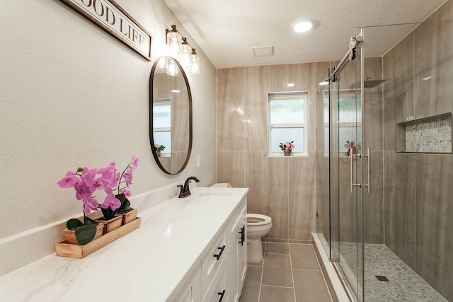 28926 Twisted Oak Dr, Shenandoah, TX 77381 - full bathroom with vanity, a shower stall, tile patterned flooring, and a textured ceiling