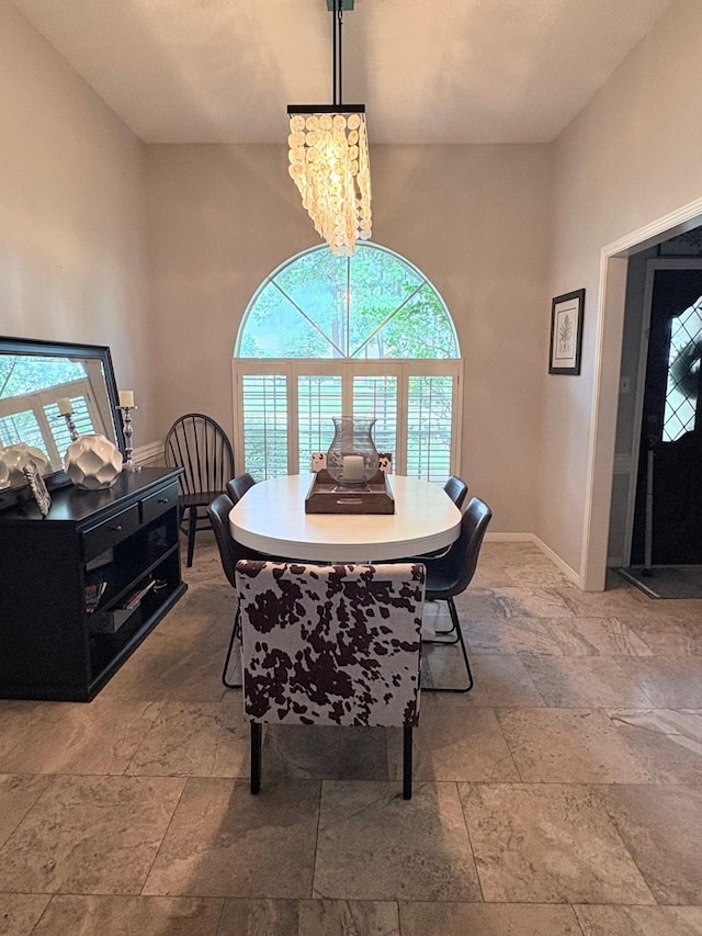 8819 W Rayford Rd, Tomball, TX 77375 - dining room featuring stone tile flooring, a chandelier, and a high ceiling