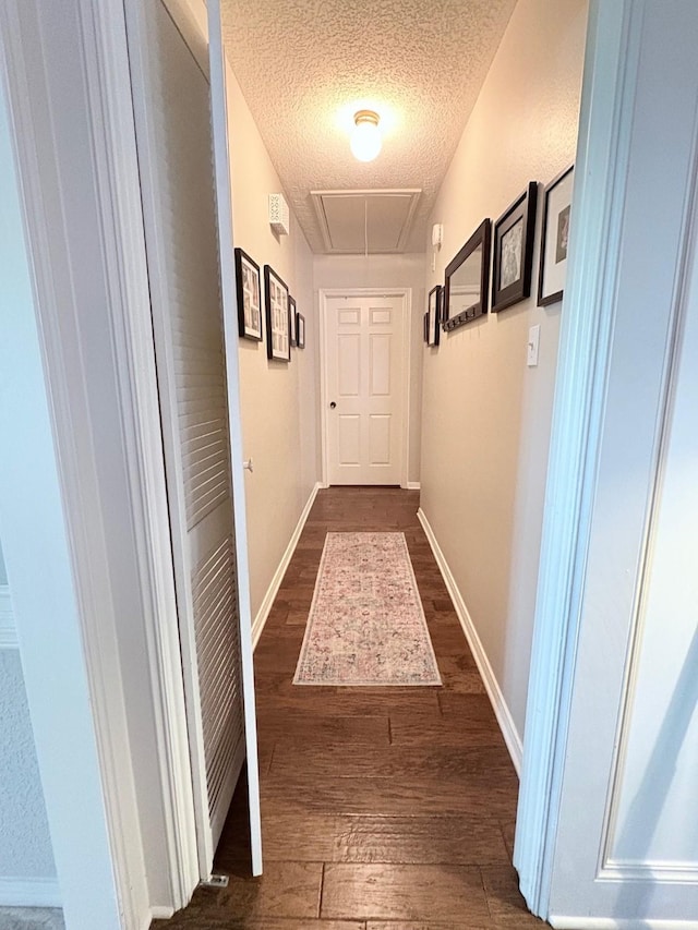 8819 W Rayford Rd, Tomball, TX 77375 - hall featuring attic access, dark wood-type flooring, and a textured ceiling