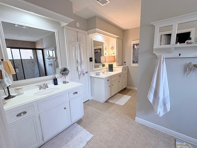 8819 W Rayford Rd, Tomball, TX 77375 - full bathroom featuring a stall shower, tile patterned flooring, two vanities, and a textured ceiling