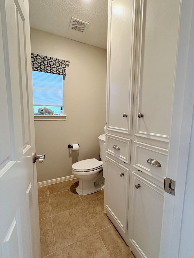 8819 W Rayford Rd, Tomball, TX 77375 - bathroom featuring tile patterned flooring and a textured ceiling