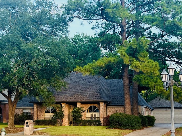 8819 W Rayford Rd, Tomball, TX 77375 - view of front of home with roof with shingles, brick siding, a front lawn, and a garage