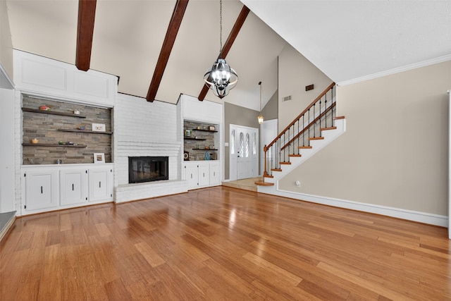 5903 Havenwoods Dr, Houston, TX 77066 - unfurnished living room with light wood-style flooring, stairs, a fireplace, high vaulted ceiling, and a chandelier