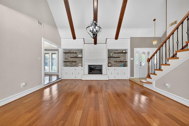 5903 Havenwoods Dr, Houston, TX 77066 - unfurnished living room featuring wood finished floors, a chandelier, stairs, a fireplace, and beam ceiling