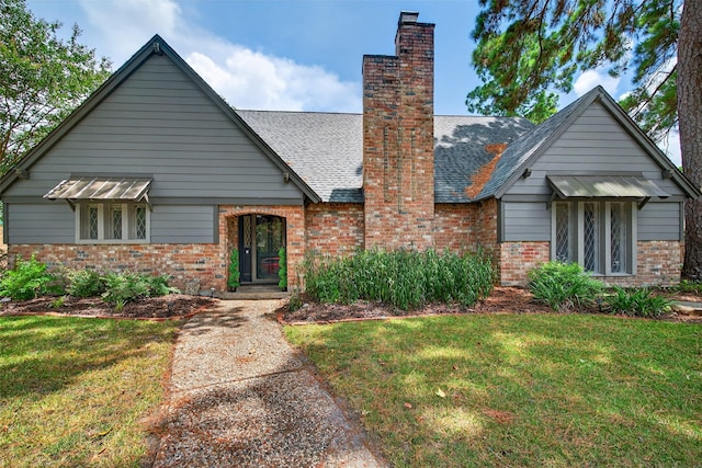 5903 Havenwoods Dr, Houston, TX 77066 - view of front of house with brick siding, a chimney, a front yard, and a shingled roof