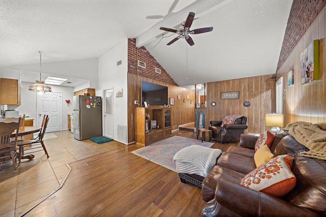 2121 Redwood St, Kemah, TX 77565 - living area with wooden walls, a ceiling fan, light wood-type flooring, beam ceiling, and high vaulted ceiling