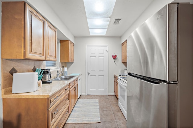 2121 Redwood St, Kemah, TX 77565 - kitchen with freestanding refrigerator, electric range, light countertops, tasteful backsplash, and light tile patterned flooring