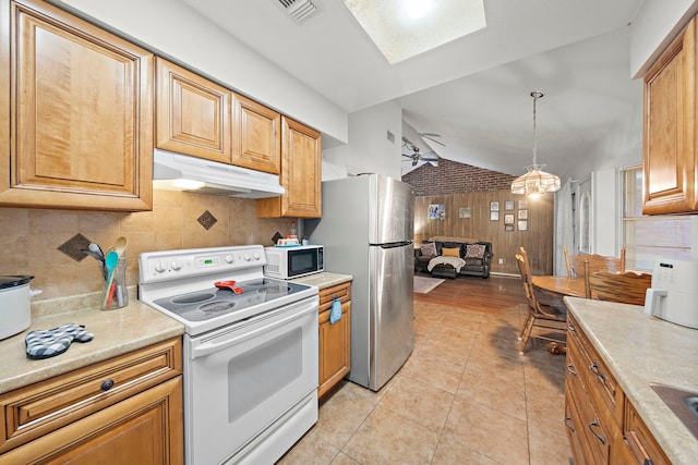 2121 Redwood St, Kemah, TX 77565 - kitchen with electric stove, under cabinet range hood, lofted ceiling, freestanding refrigerator, and tasteful backsplash
