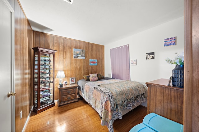 2121 Redwood St, Kemah, TX 77565 - bedroom featuring wood walls and light wood-style floors