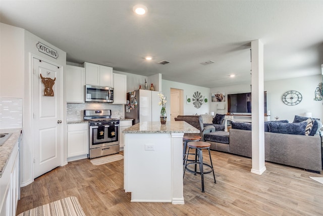 1007 Cozumel Emerald, San Antonio, TX 78253 - kitchen featuring stainless steel appliances, open floor plan, a kitchen bar, light wood-style floors, and recessed lighting