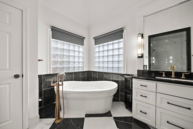 1229 Ripple Creek Dr, Houston, TX 77057 - bathroom with tile walls, marble tiled floors, vanity, a wainscoted wall, and a soaking tub