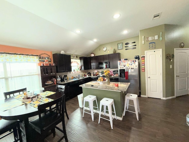 2315 Shady Tree Ln, Conroe, TX 77301 - kitchen featuring stainless steel refrigerator with ice dispenser, black microwave, a kitchen island, a kitchen bar, and dark wood-style floors