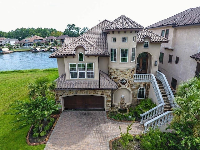 12349 Tramonto Dr, Conroe, TX 77304 - mediterranean / spanish house with stone siding, stucco siding, a garage, and decorative driveway