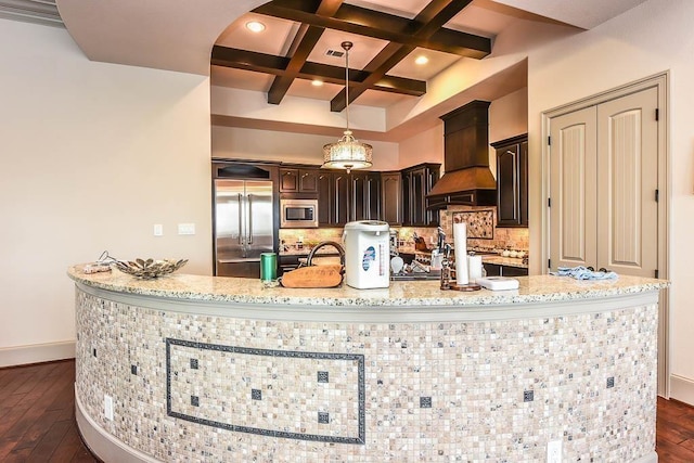 12349 Tramonto Dr, Conroe, TX 77304 - kitchen featuring built in appliances, custom range hood, coffered ceiling, dark brown cabinetry, and dark wood-type flooring