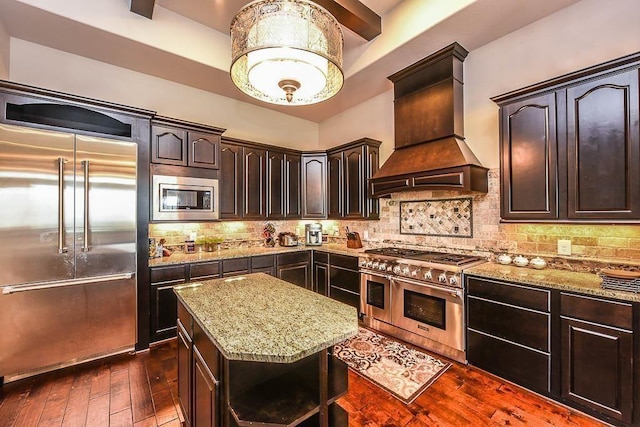12349 Tramonto Dr, Conroe, TX 77304 - kitchen with built in appliances, custom exhaust hood, light stone countertops, dark brown cabinets, and dark wood-style flooring
